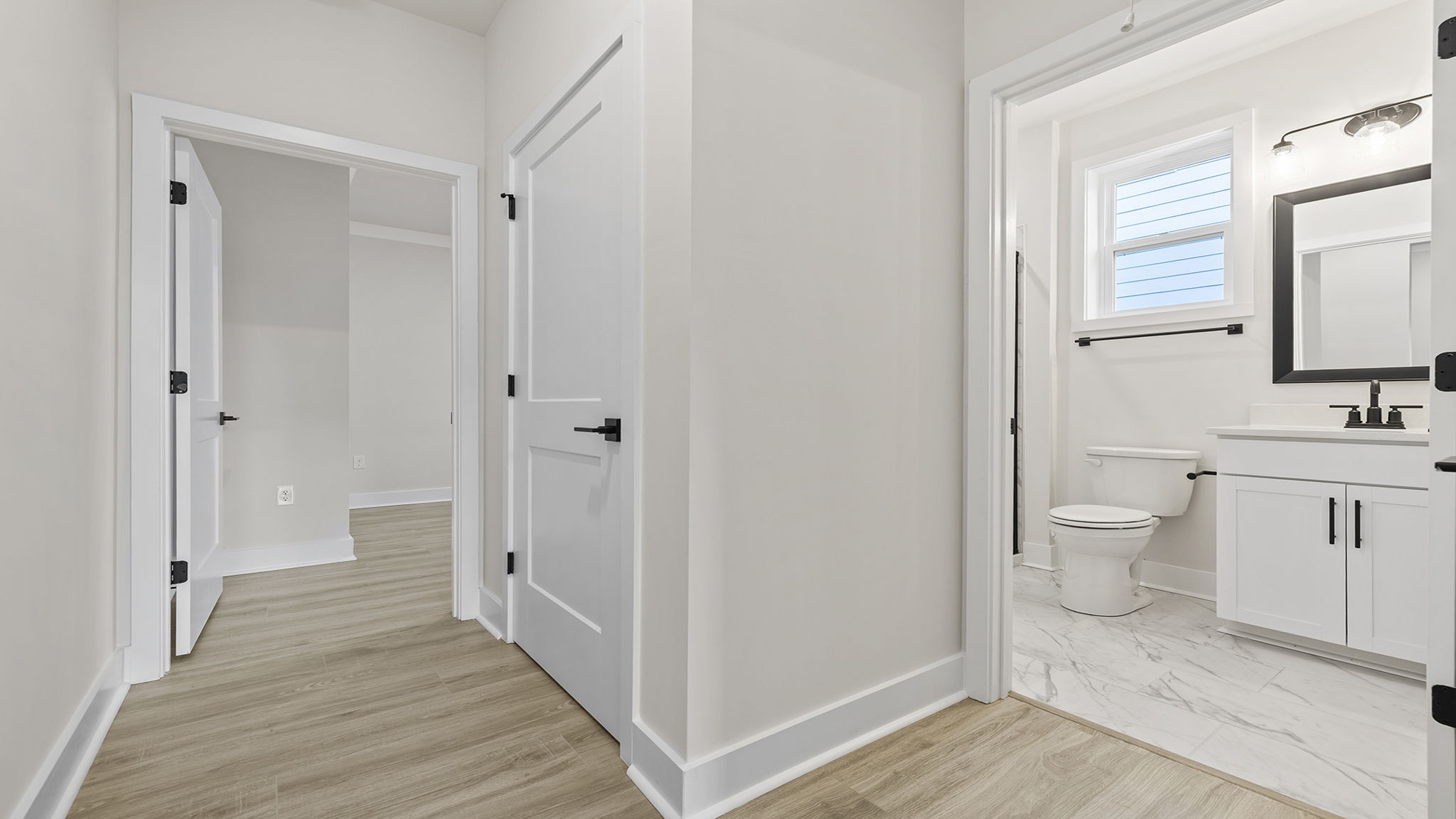 Hall bathroom and view into other bedroom.