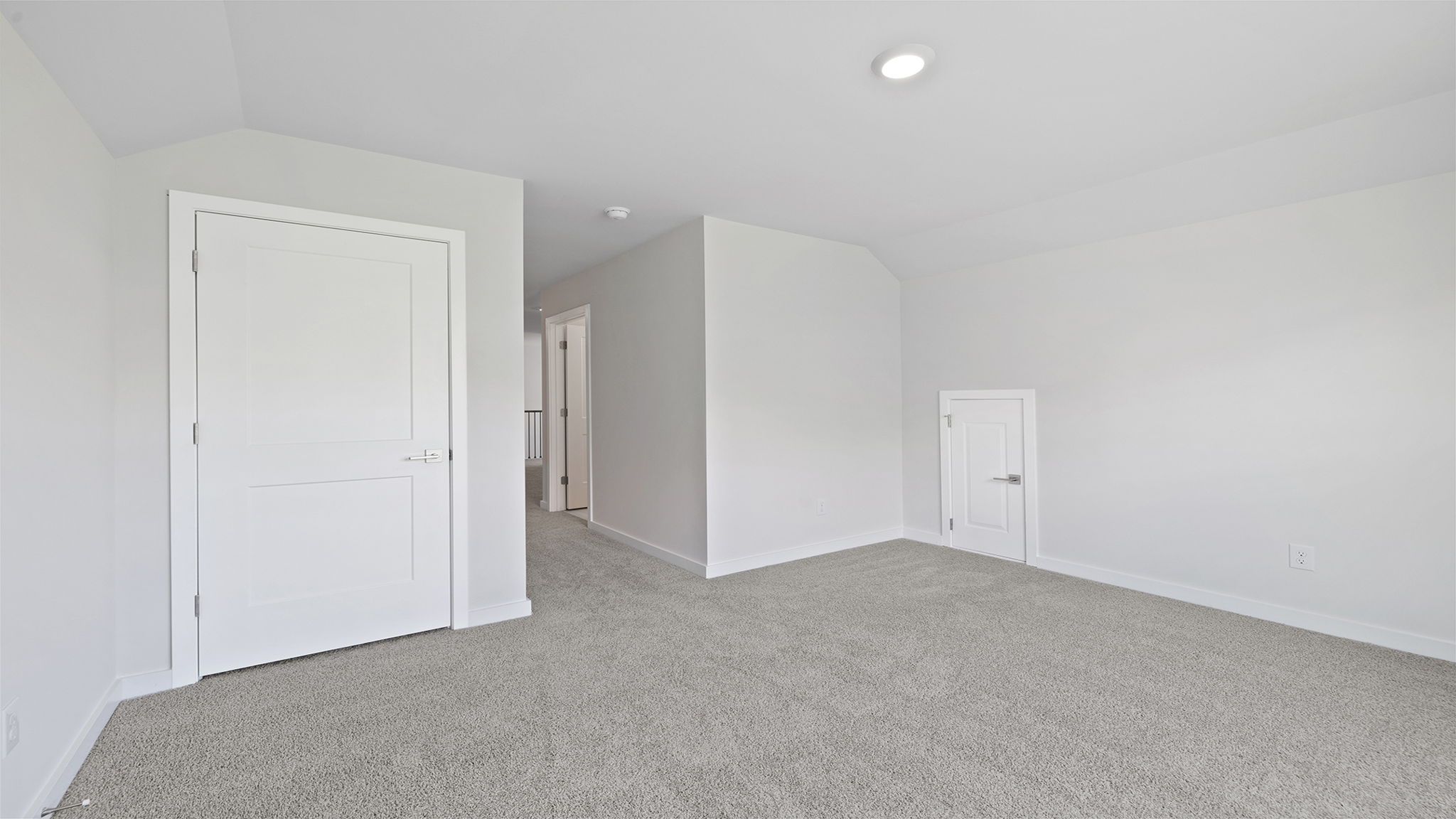 Bedroom on the upper level with large windows and carpet.