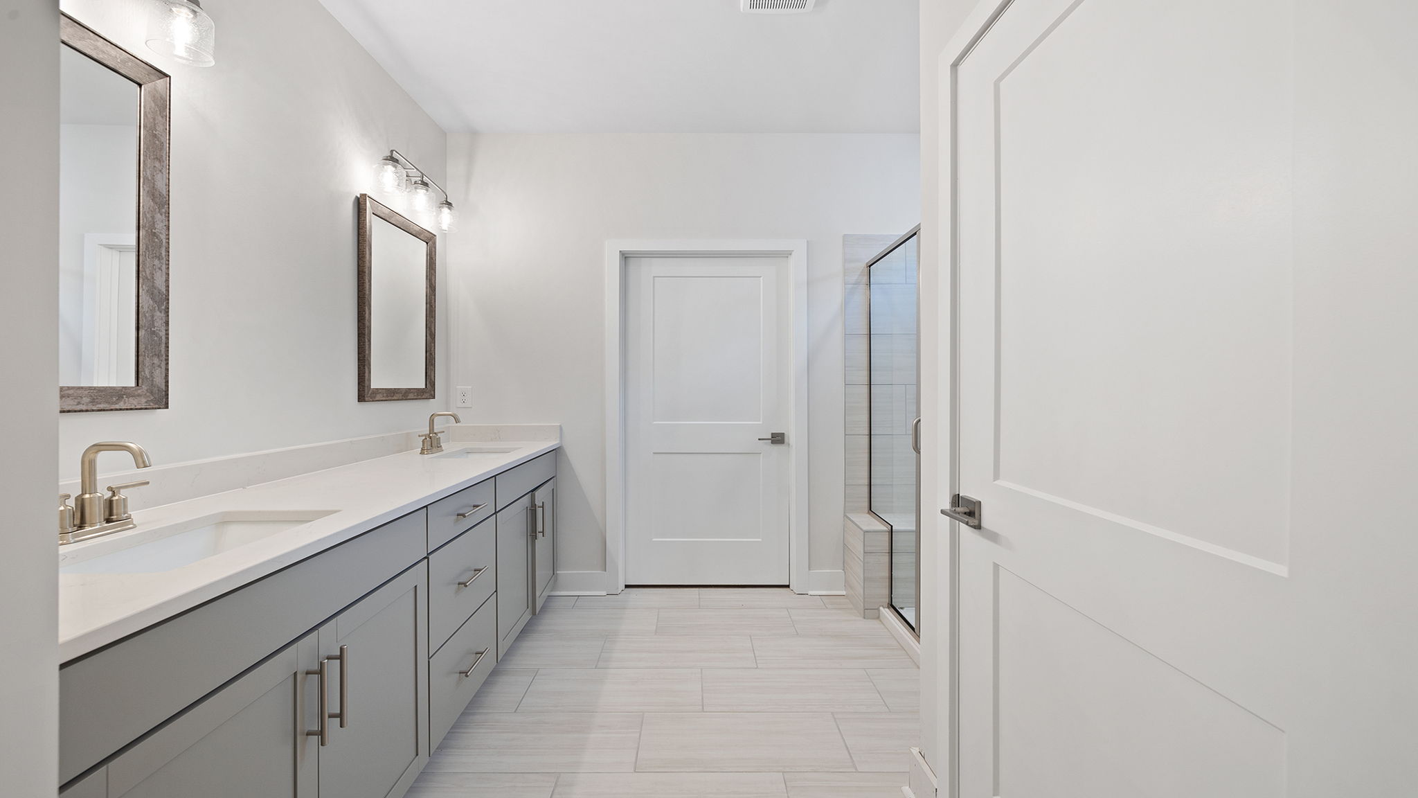 Primary bathroom with dual sink vanity and walk-in shower.