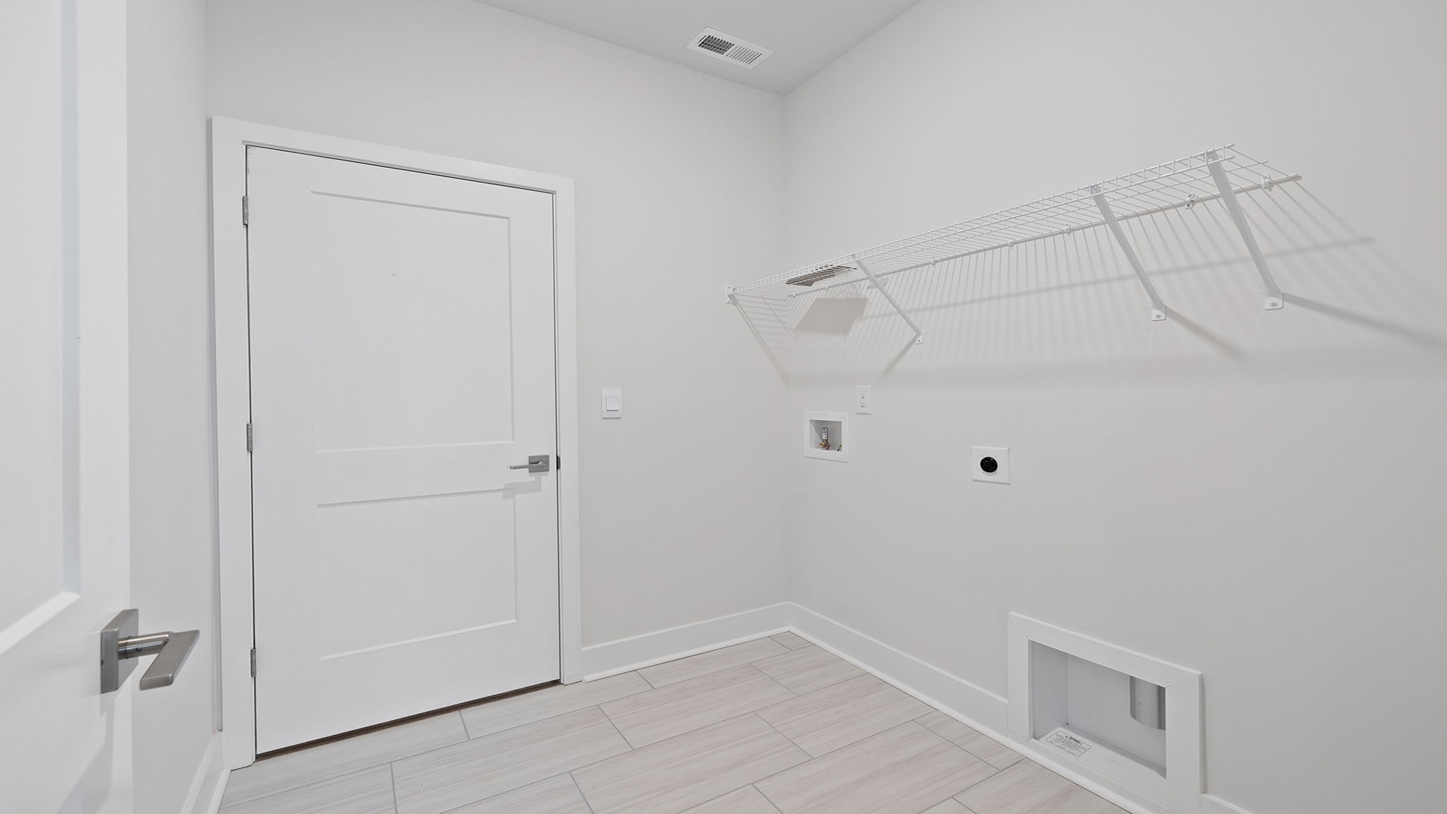 Walk-in laundry room with shelving.