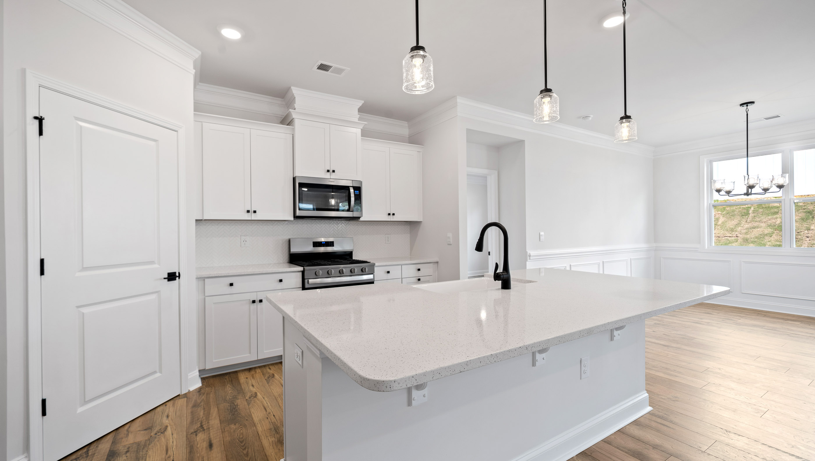 Kitchen and island with stainless steel appliances.