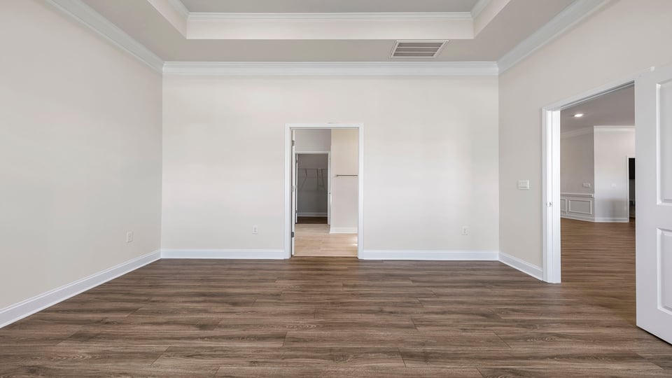 Primary bedroom with carpet and windows.
