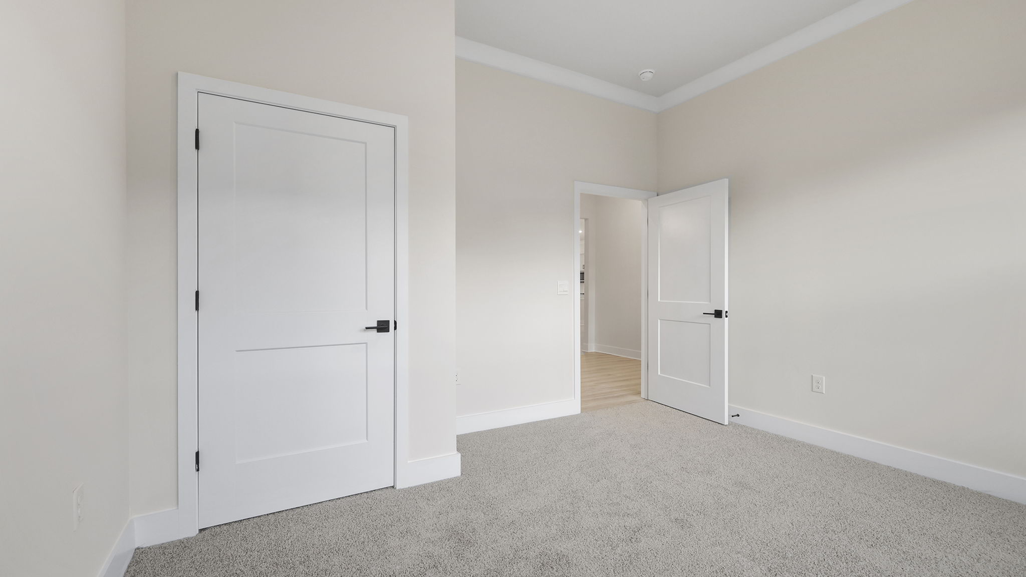 Bedroom with large windows and carpet.
