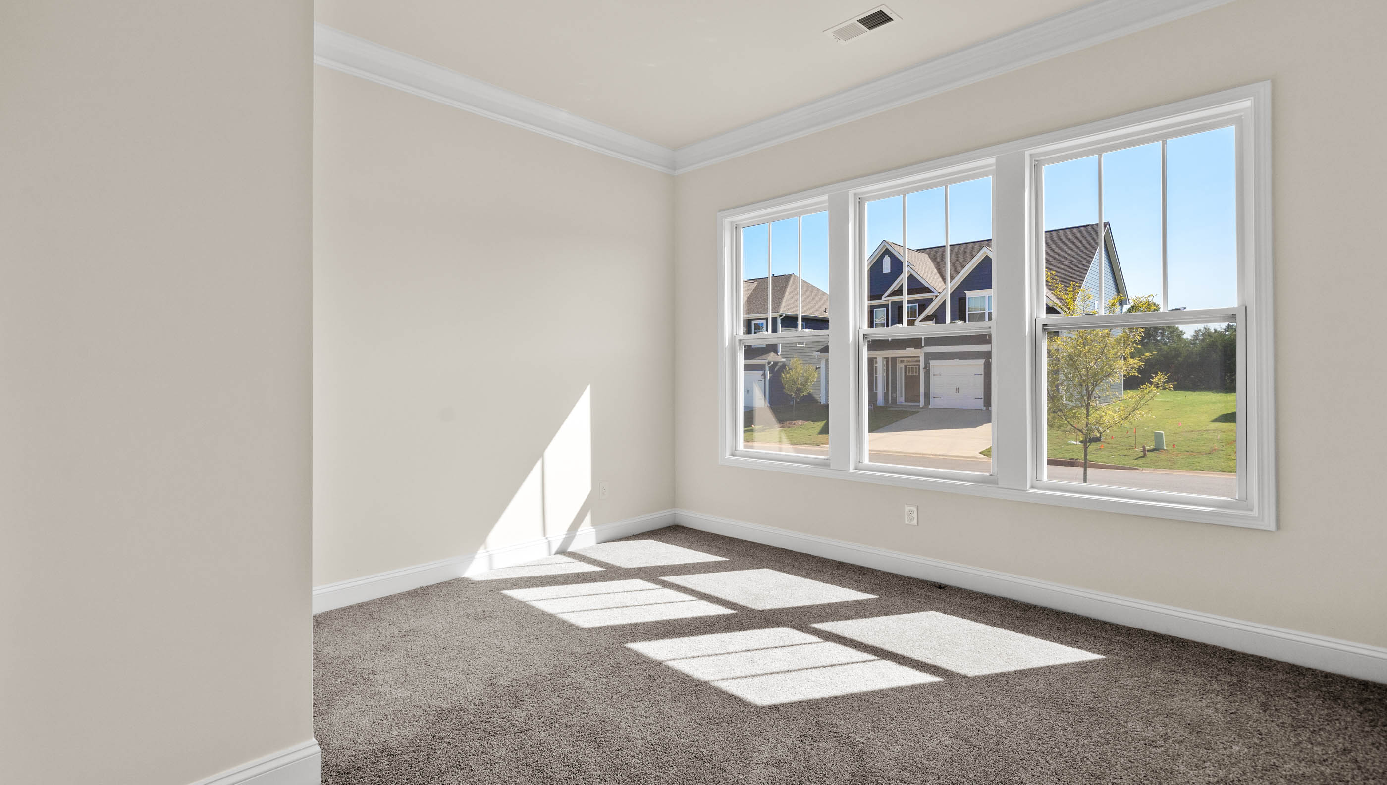Bedroom with lots of natural light and carpeting.