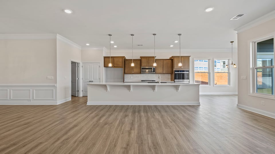 Kitchen with large island, pendulum lighting and quartz countertops.