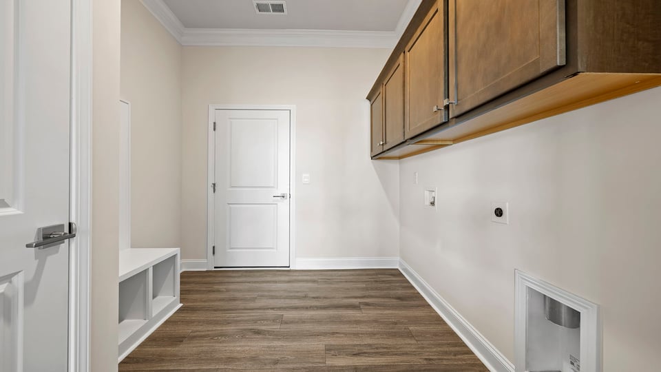 Walk in laundry room with cabinets.
