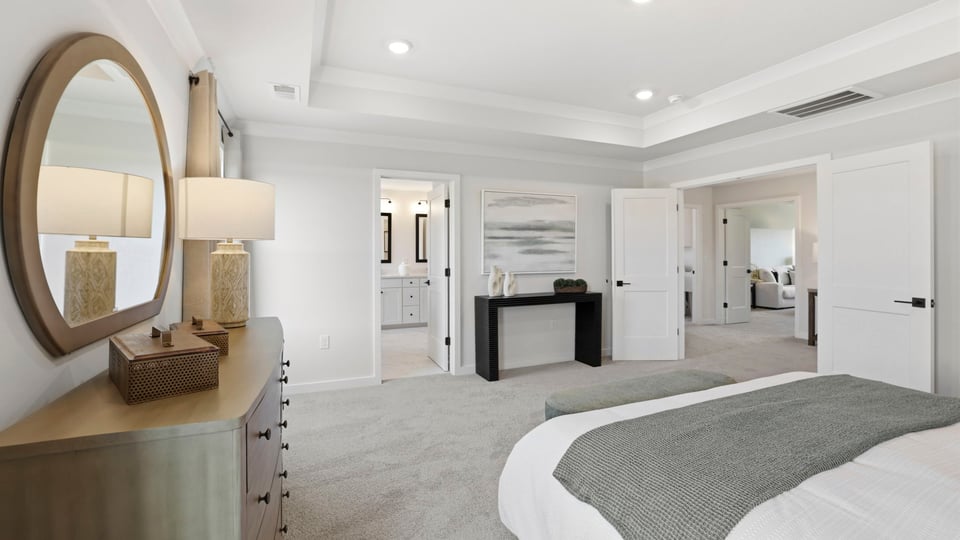 Primary bedroom with carpet and windows.