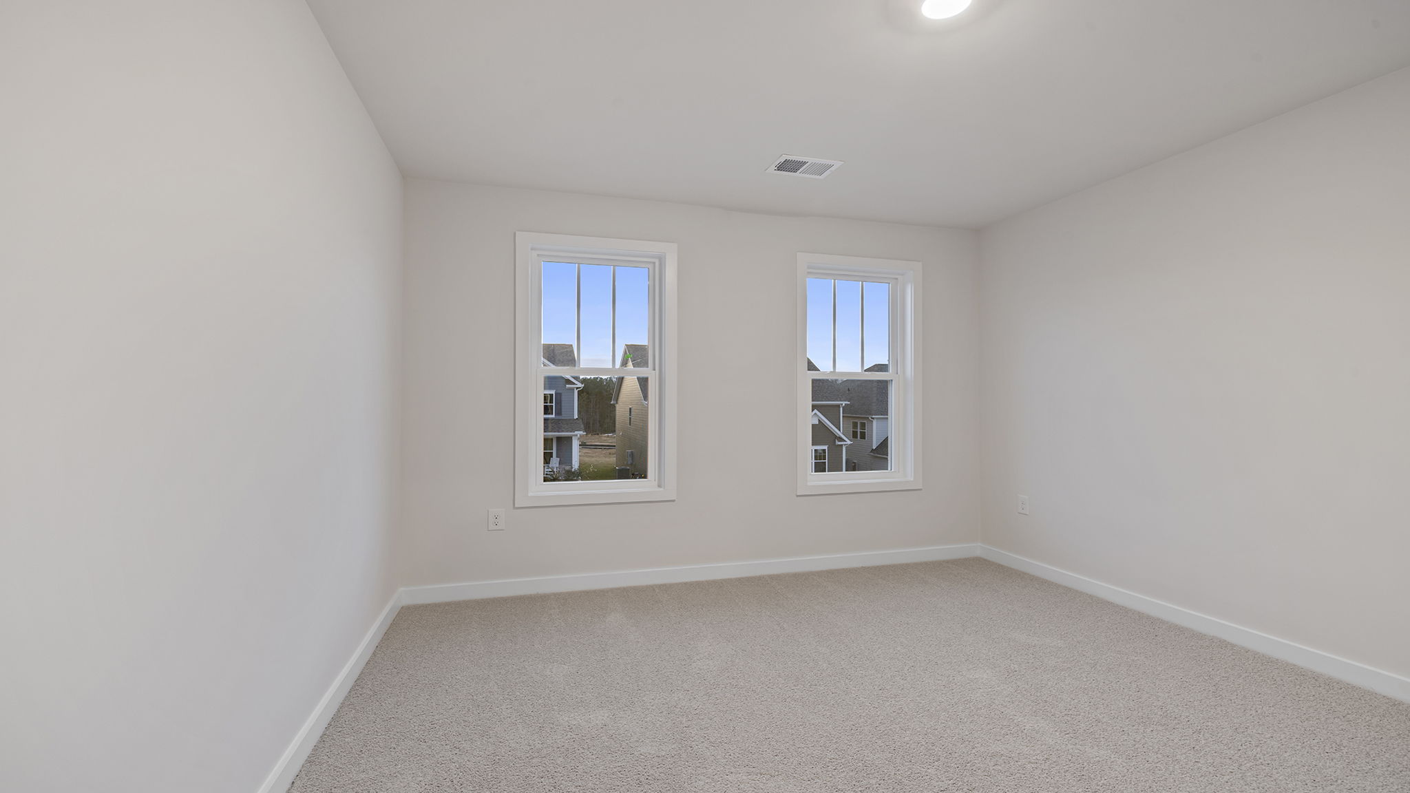Bedroom with carpet and windows.