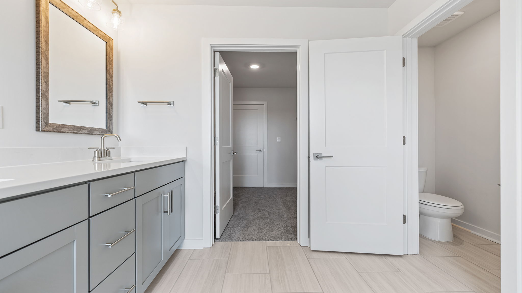 Primary bathroom with dual sink vanities.