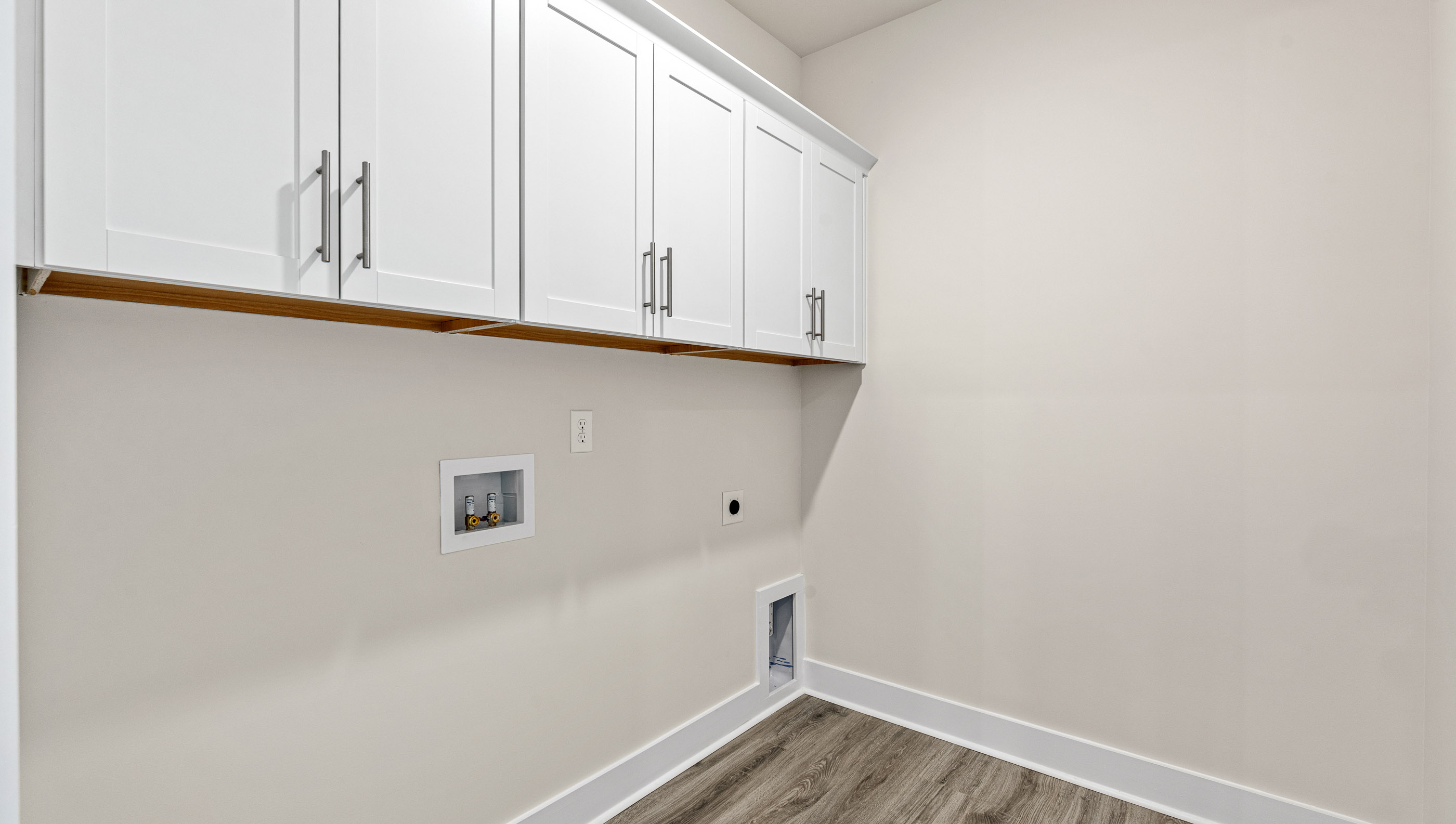 Walk-in laundry room with cabinets.