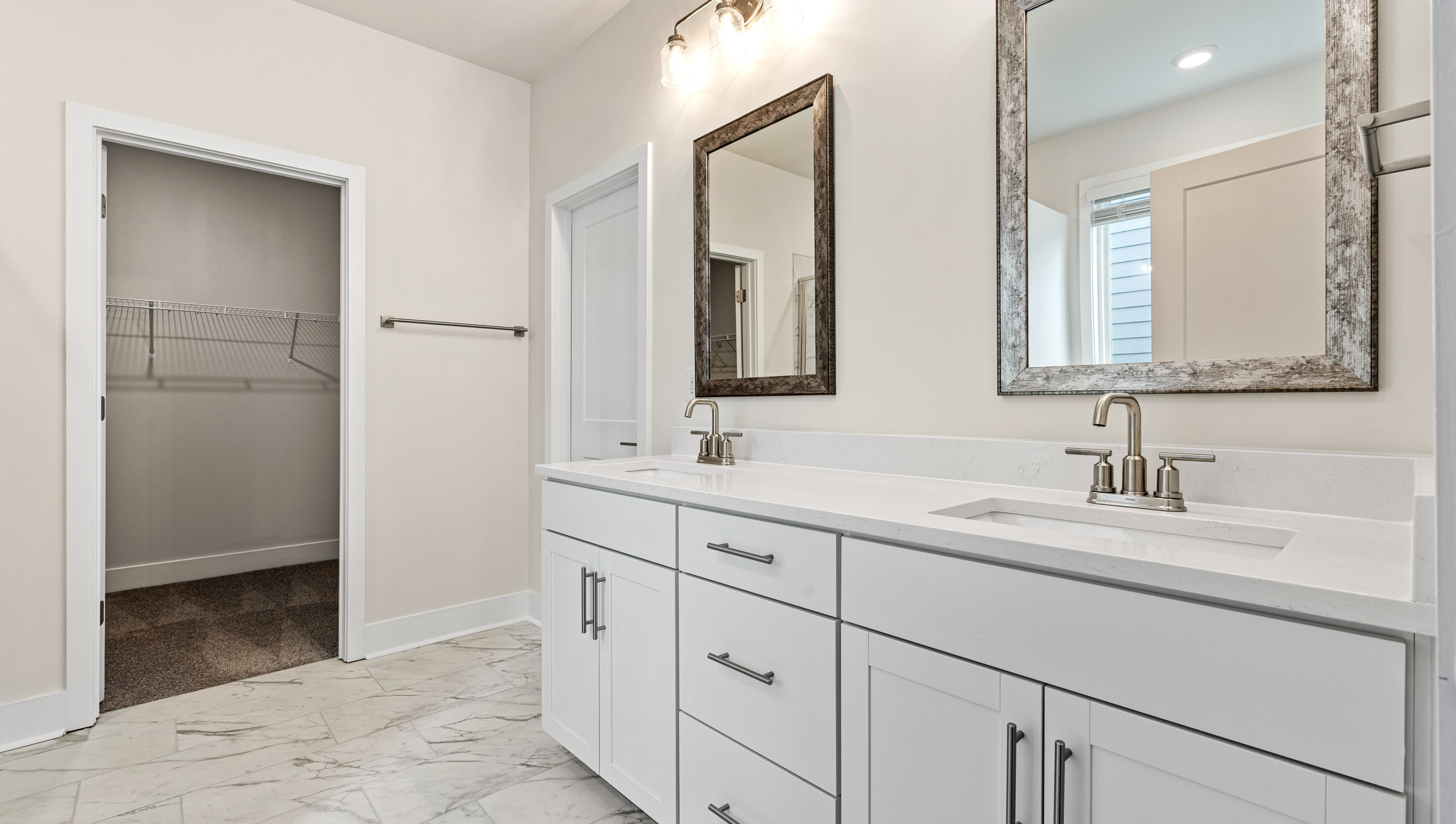 Primary bathroom dual sink vanity and closet.
