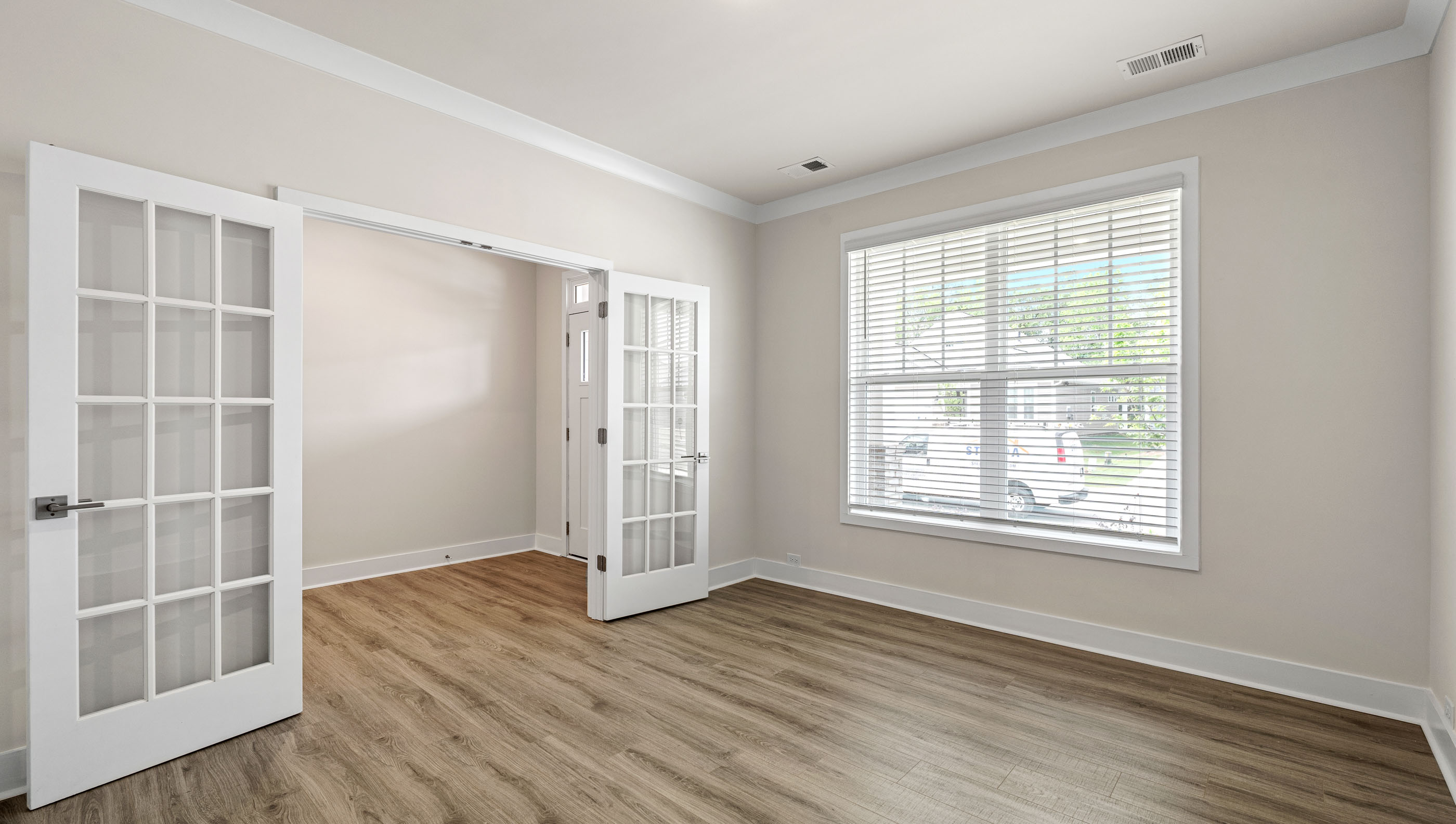 Study accented by large window and French doors.