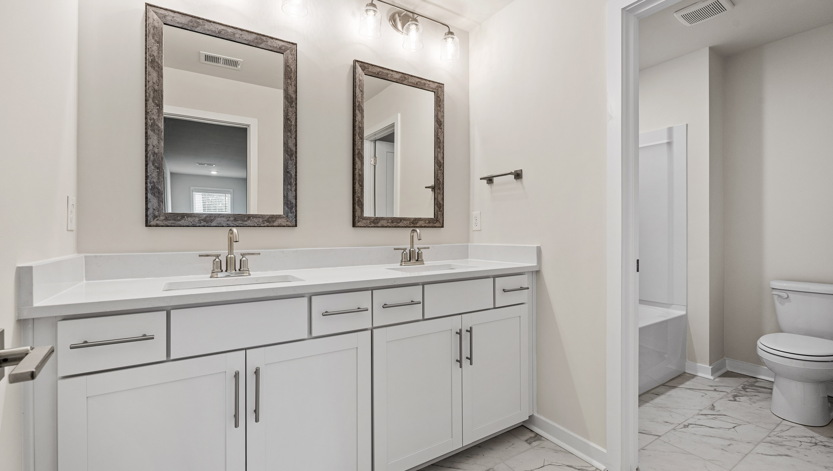 Hall bathroom with dual sink vanity separate from shower area.