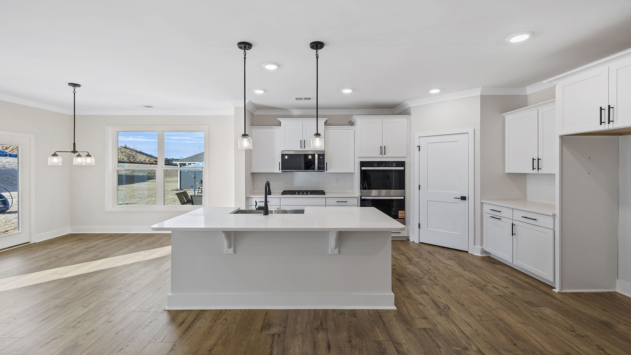Gourmet kitchen with island and pendulum lighting.