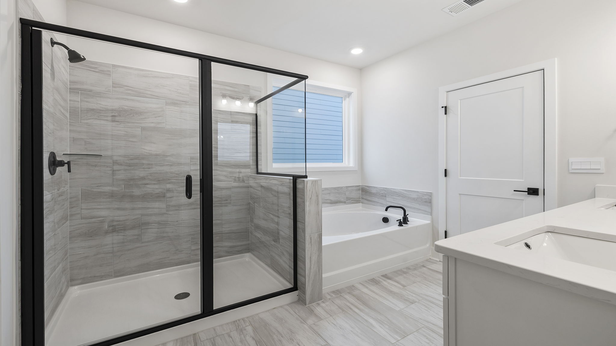 Primary bathroom with walk-in shower and garden tub.