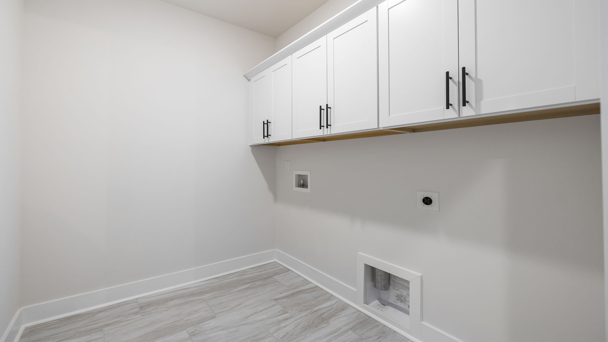 Walk-in laundry room with cabinets.