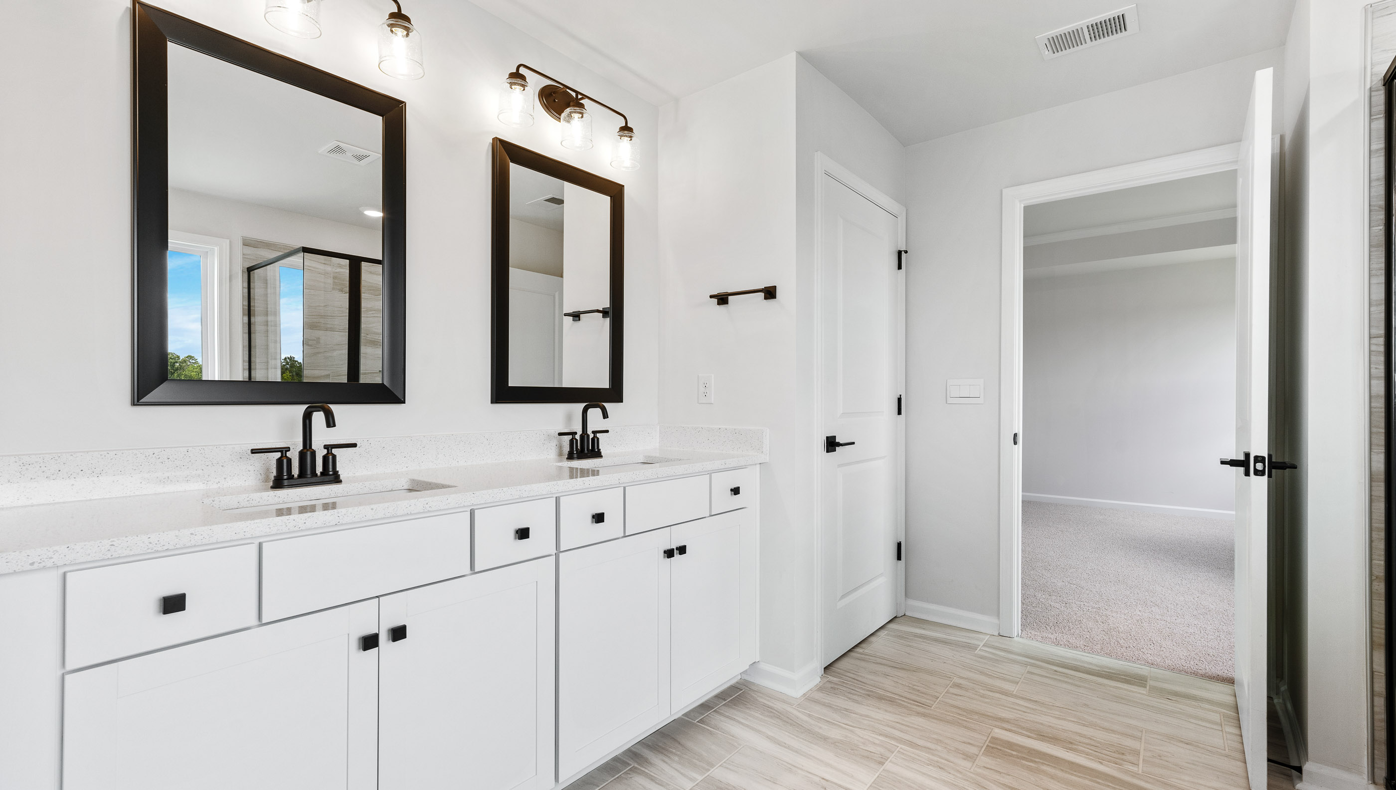 Bathroom with double vanity sink and shower.