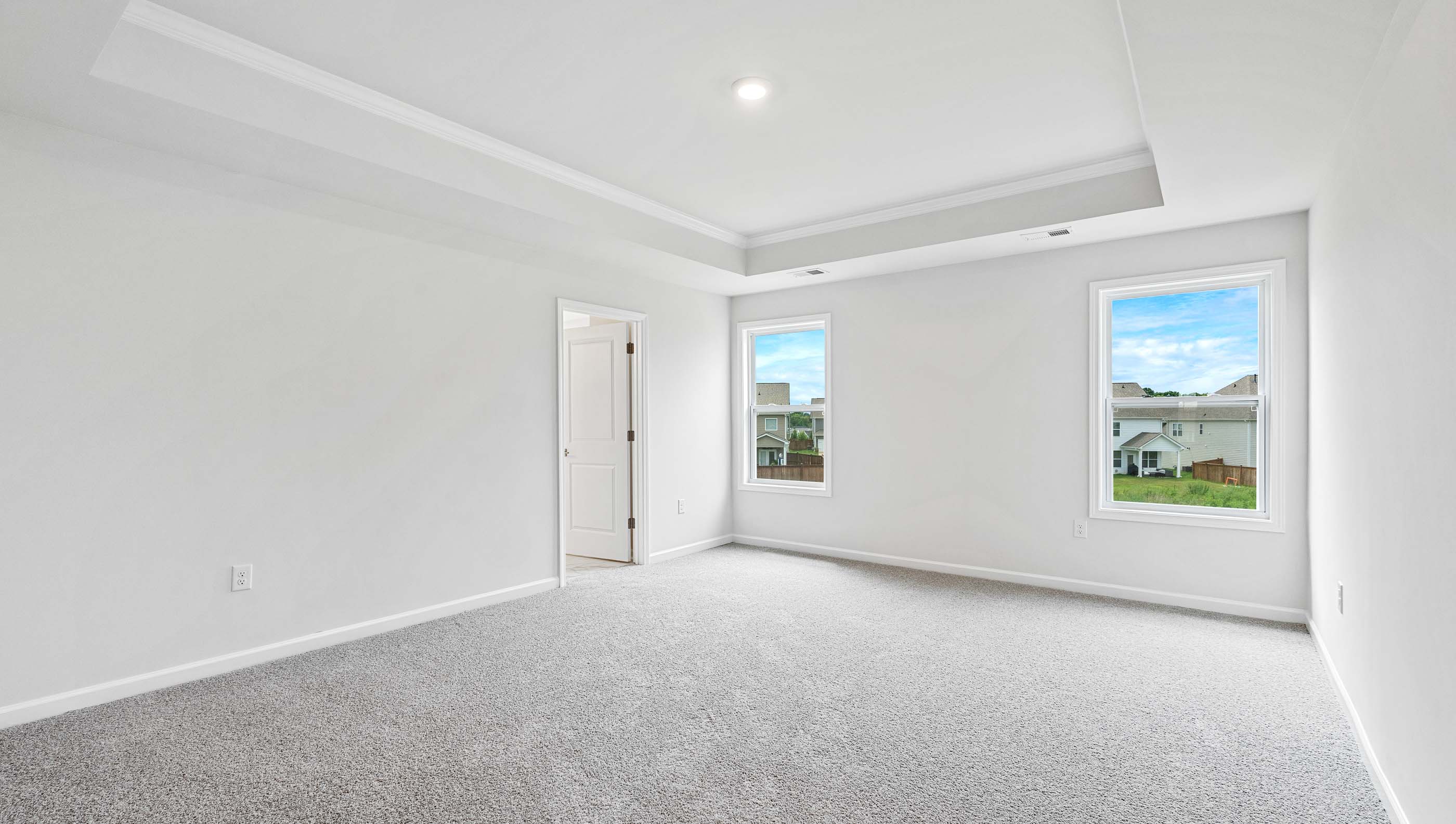 Bedroom with carpet and small windows.