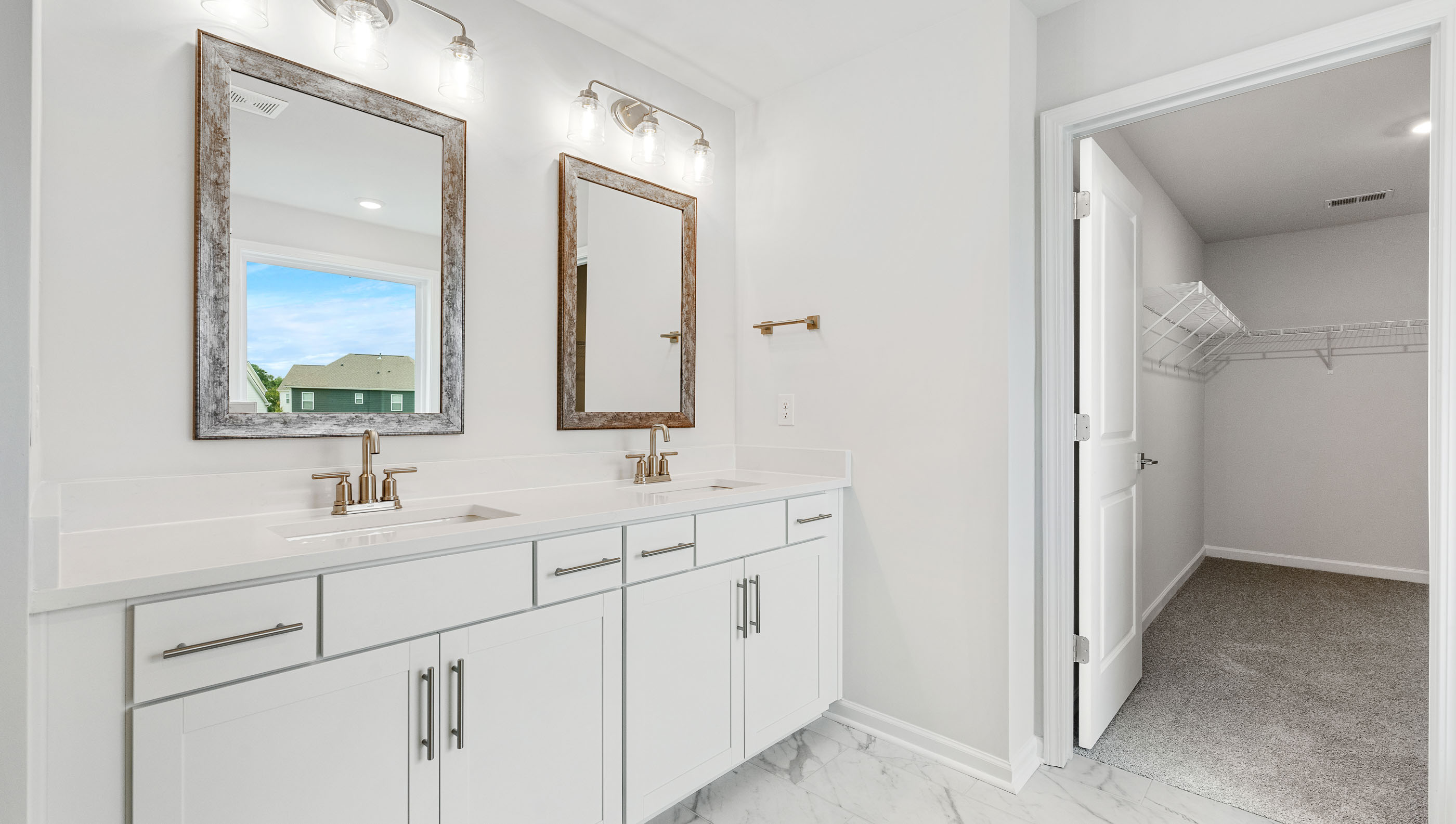 Bathroom with double vanity sink and walk in closet.