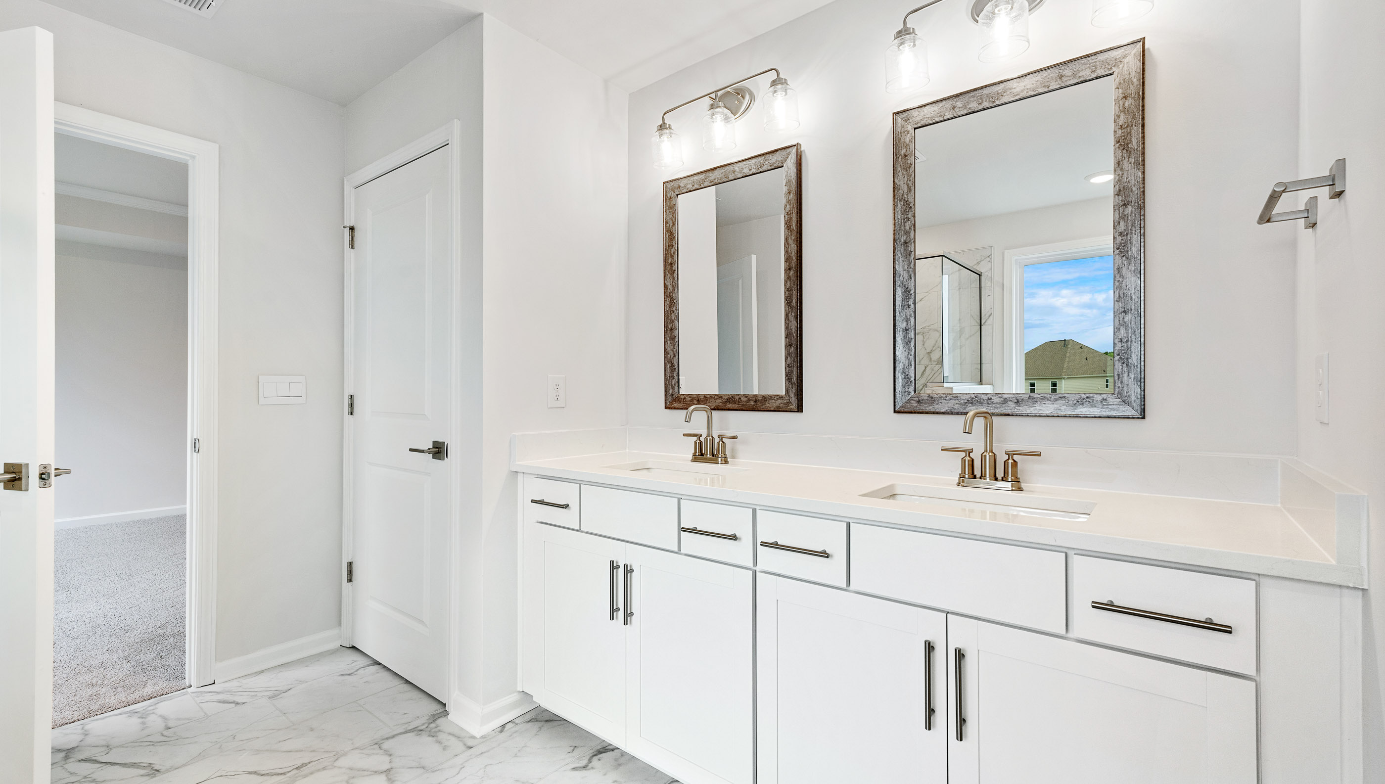 Bathroom with double vanity sink and walk in closet.