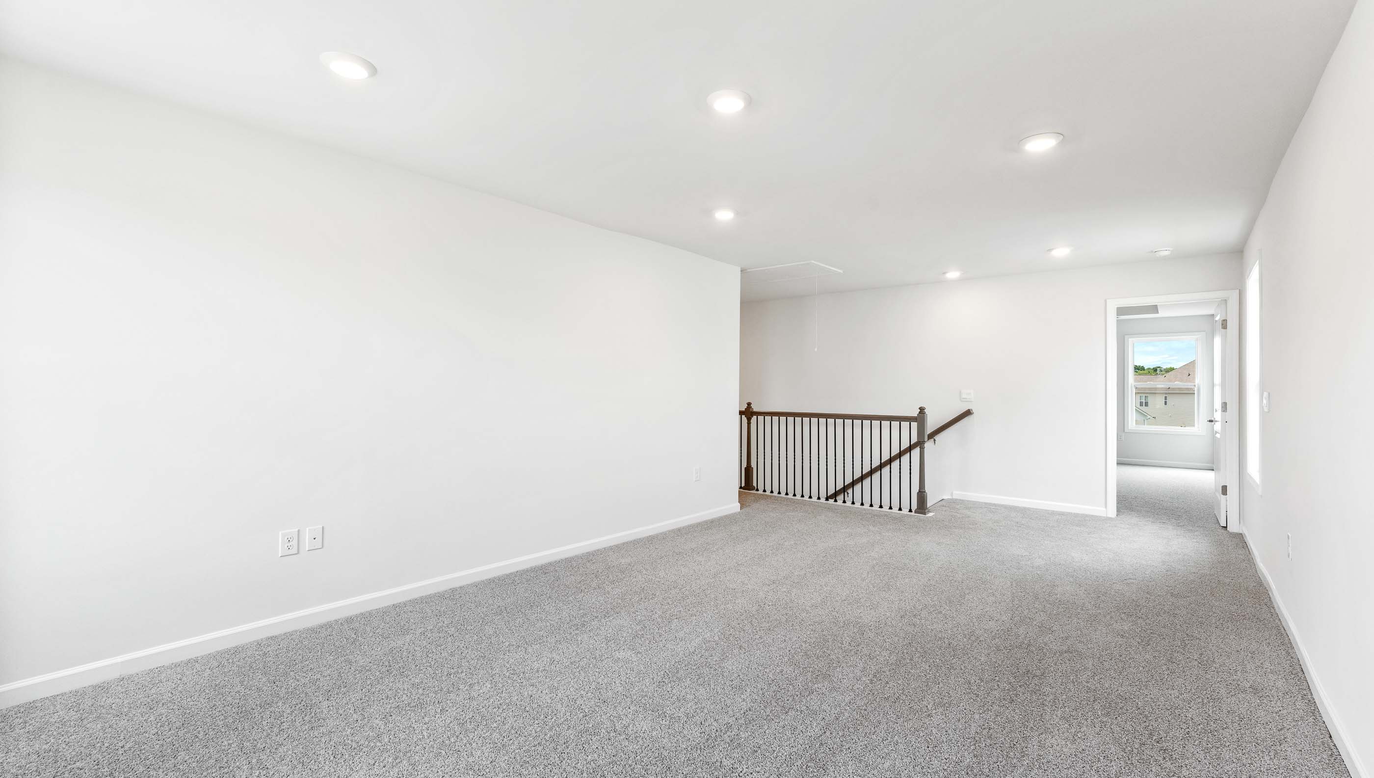 Loft area with carpet and windows.