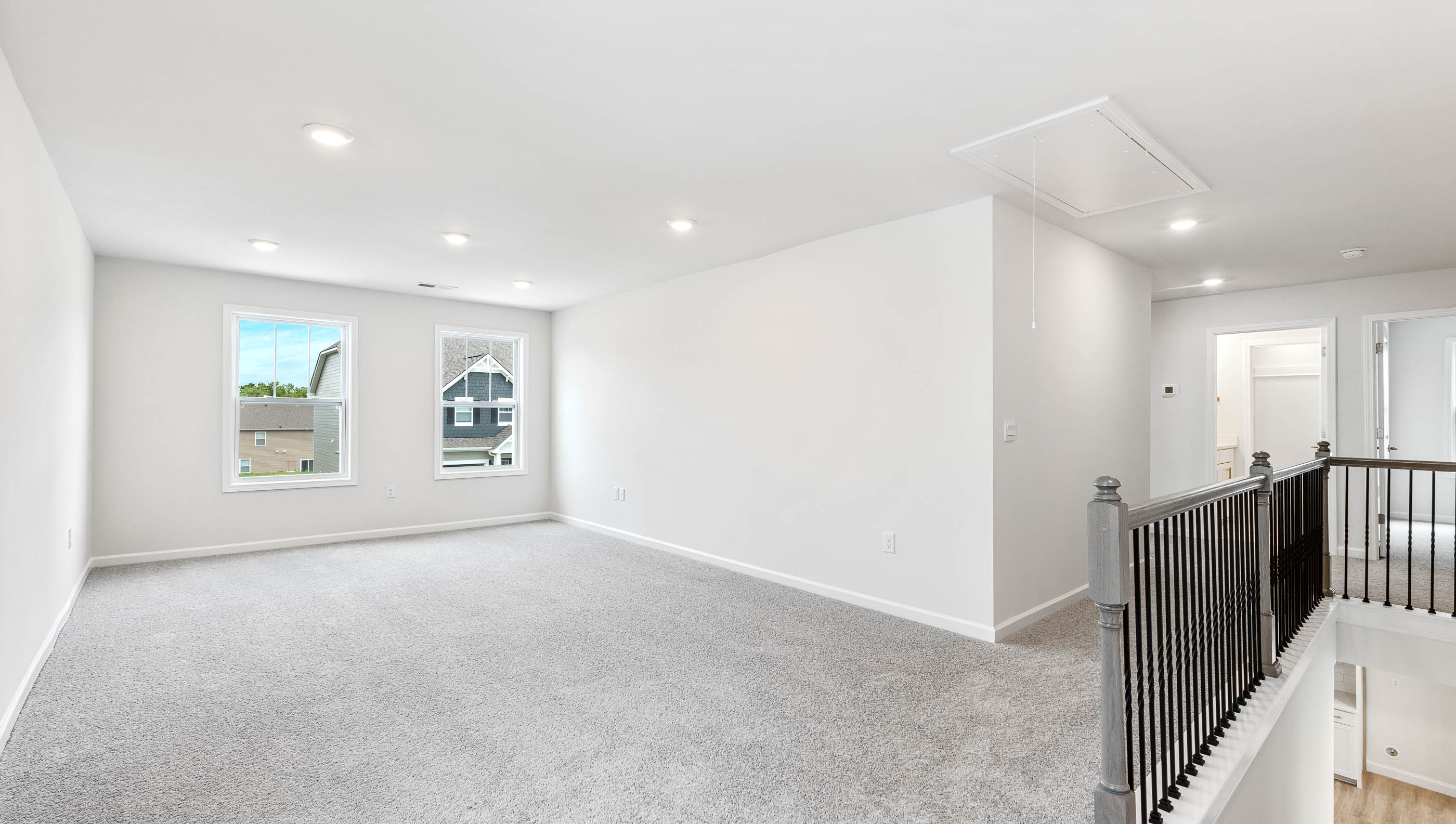 Loft area with carpet and windows.