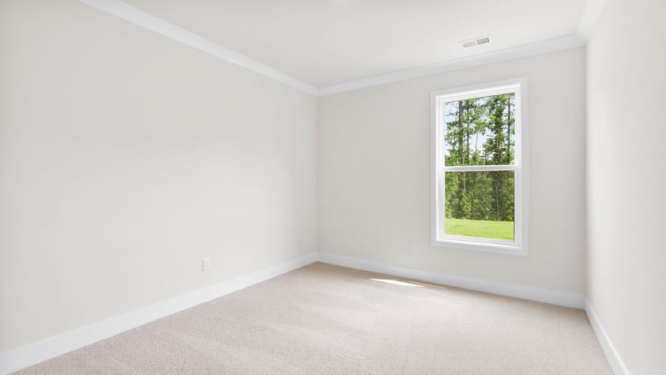 Bedroom with windows and carpet.