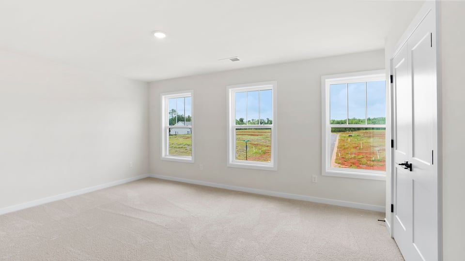 Bedroom with windows and carpet.