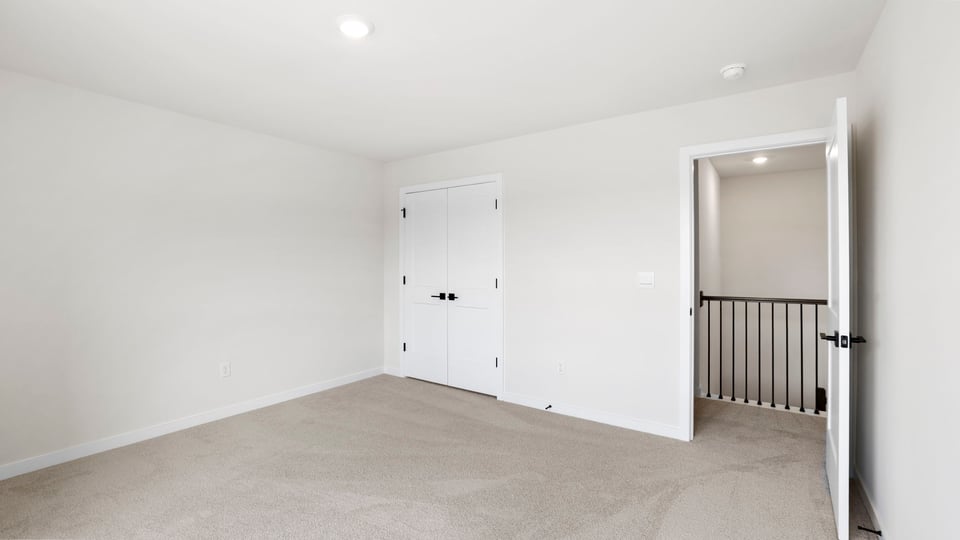 Bedroom with windows and carpet.