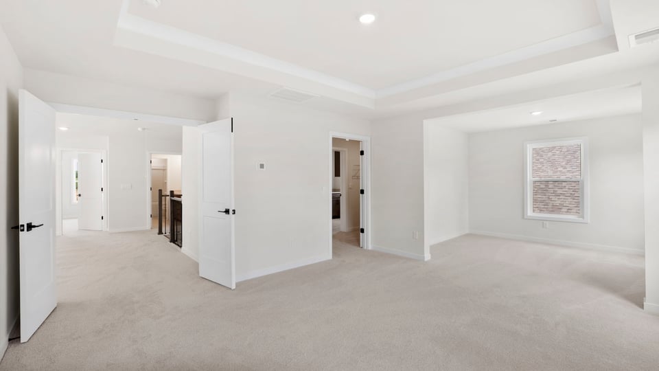 Bedroom with windows and carpet.