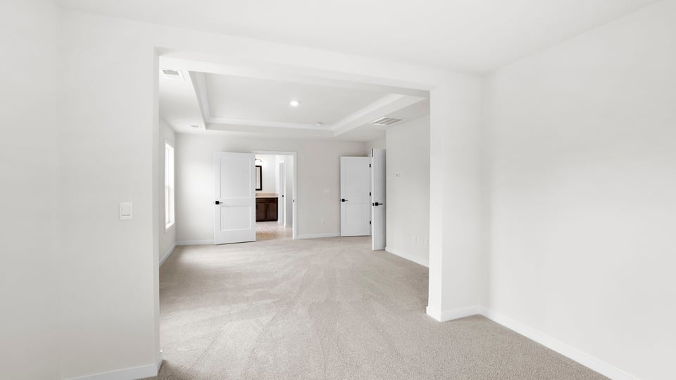 Bedroom with windows and carpet.