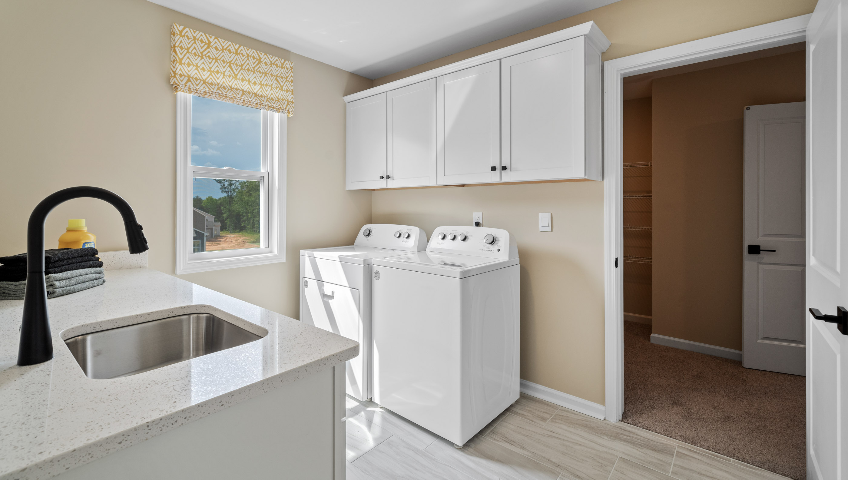Laundry room with sink and cabinets.