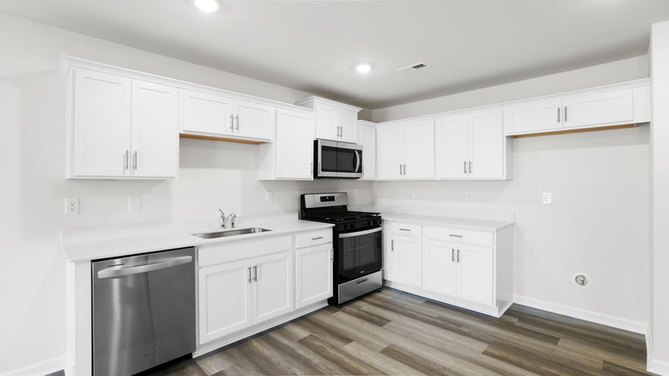 Kitchen with quartz countertops and stainless steel appliances.