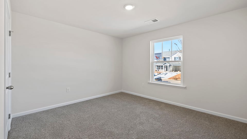 Bedroom with carpet and windows.