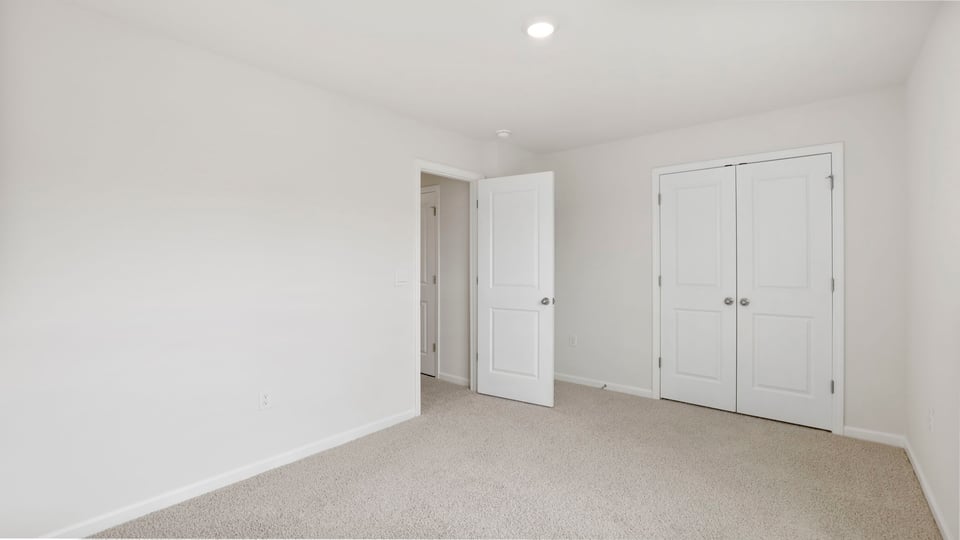 Bedroom with carpet and window.