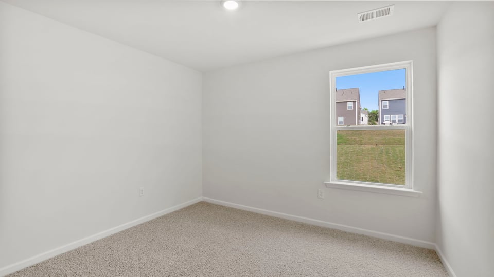 Bedroom with carpet and window.