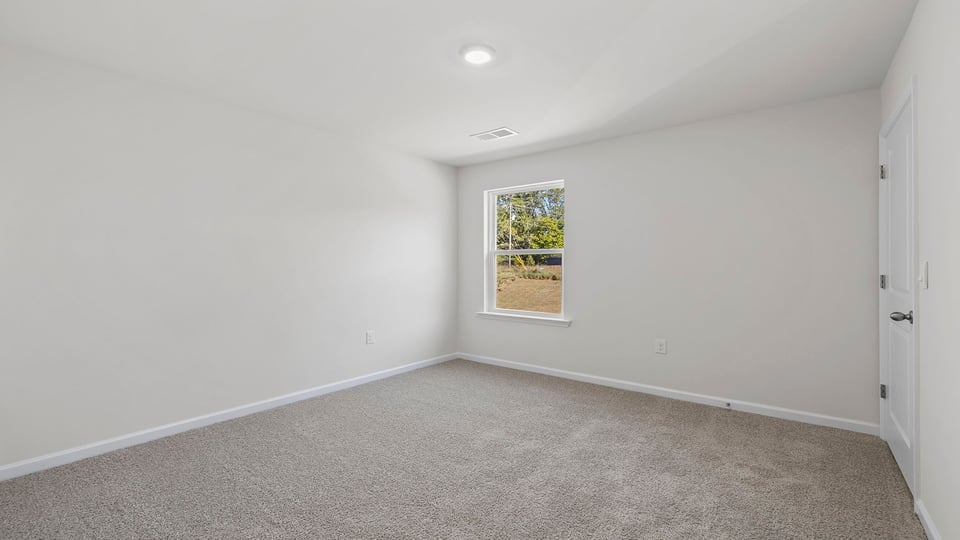 Bedroom with carpet and windows.