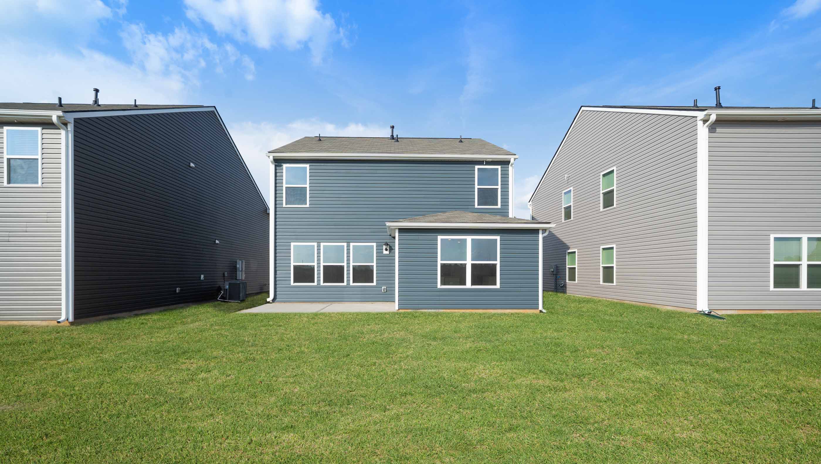 Bac exterior of home with large backyard.