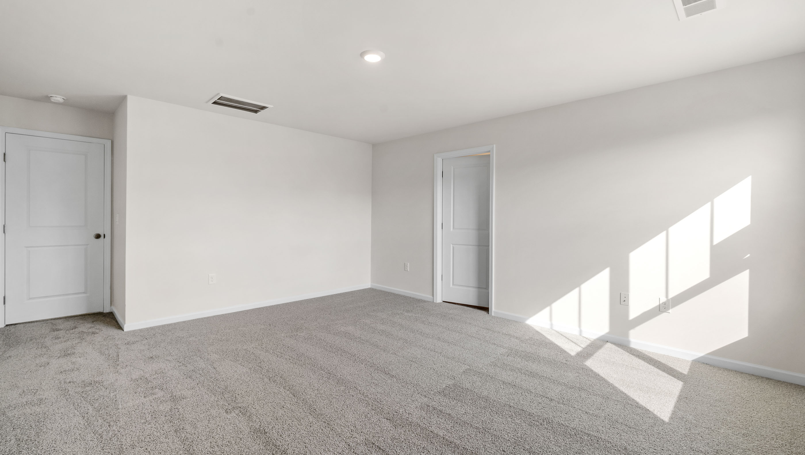 Bedroom with carpet and windows.