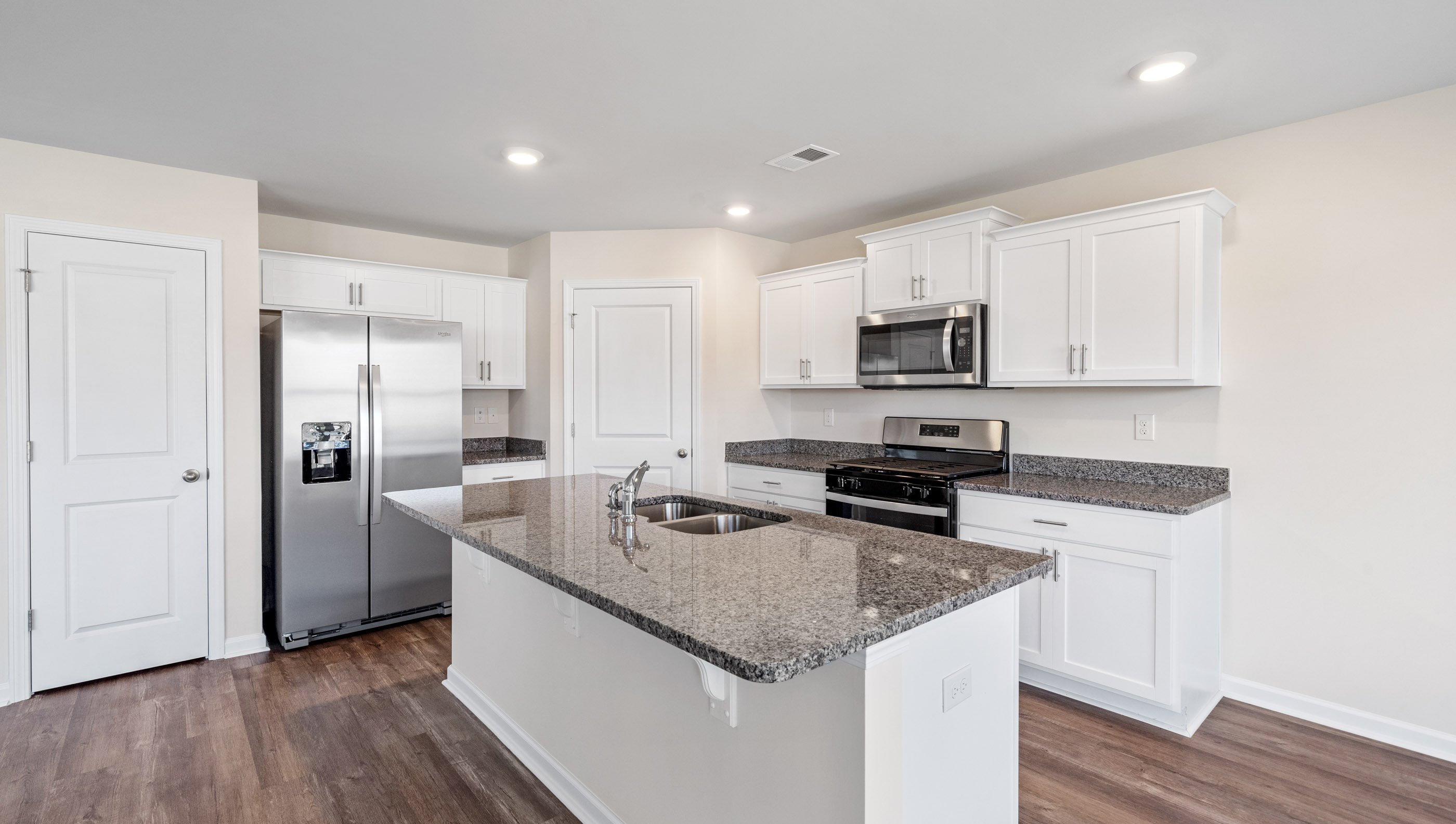 Kitchen and island with granite counter tops.