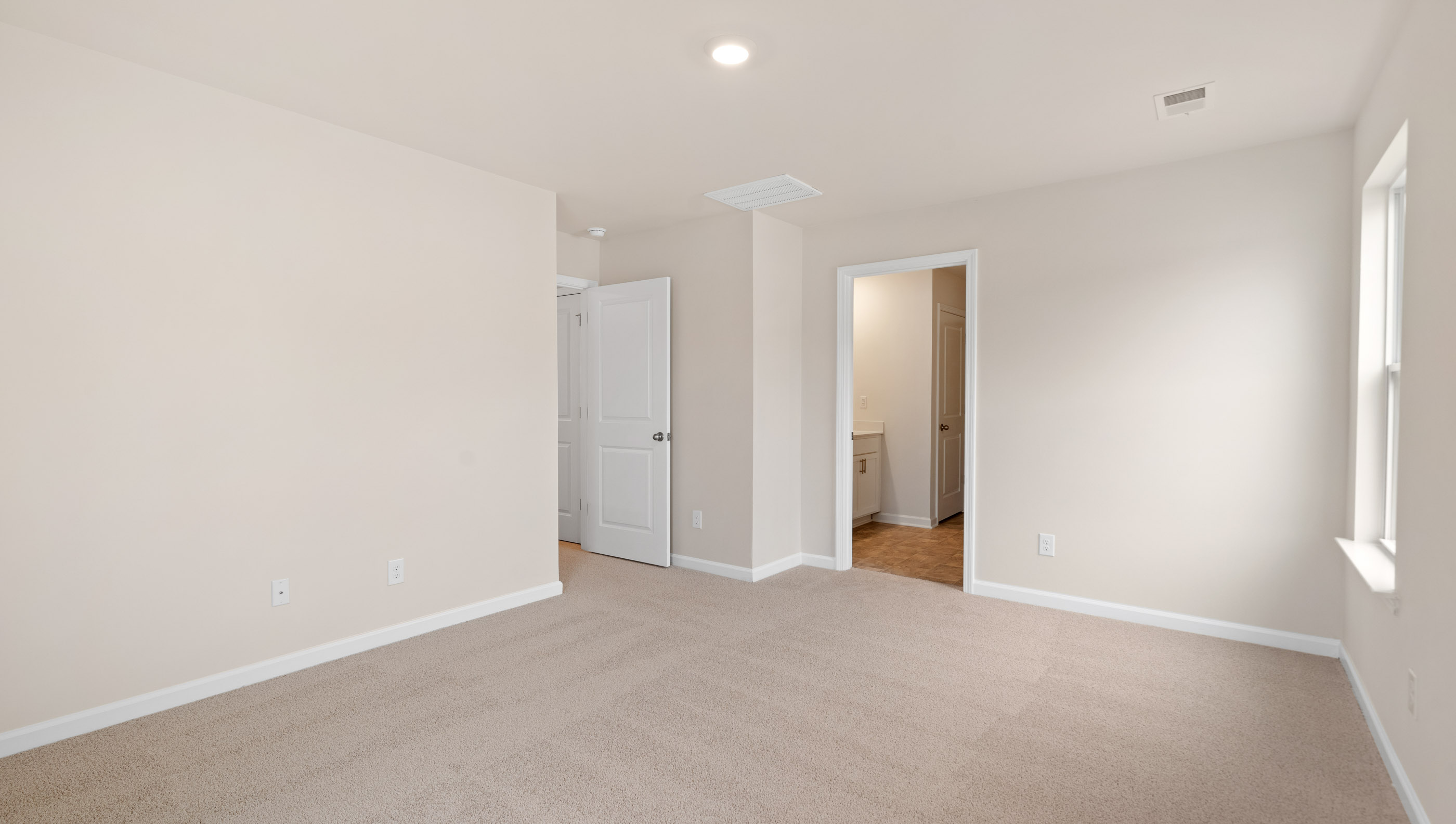 Bedroom with carpet and window.