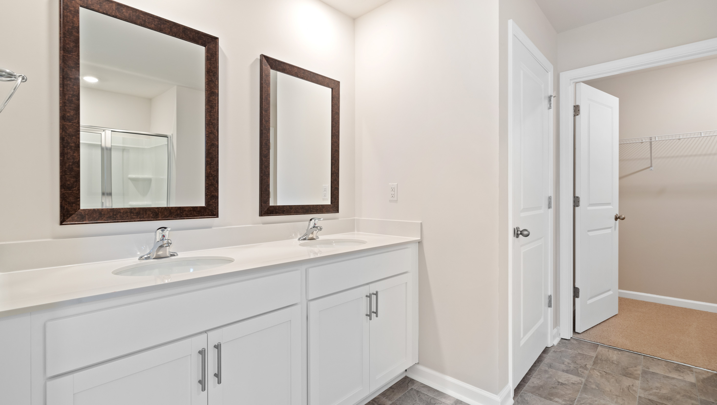 Bathroom with double vanity sink and walk in shower.