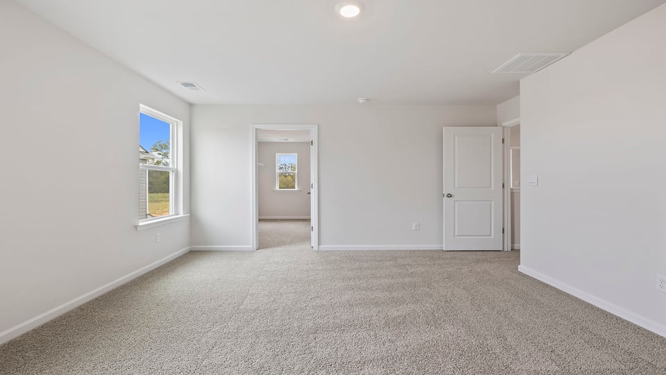 Bedroom with carpet and windows.