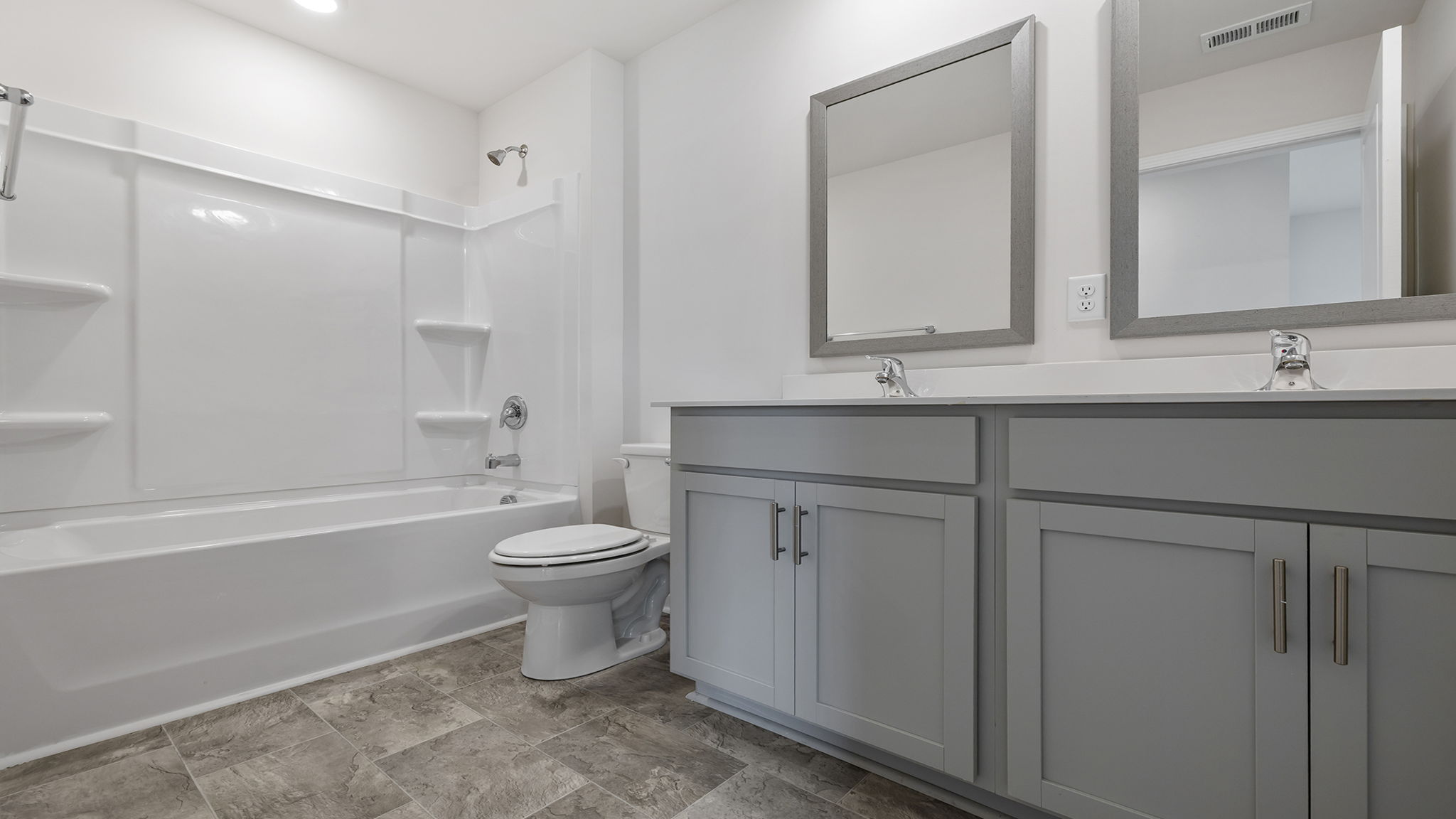 Bathroom with double sink vanity and tub.