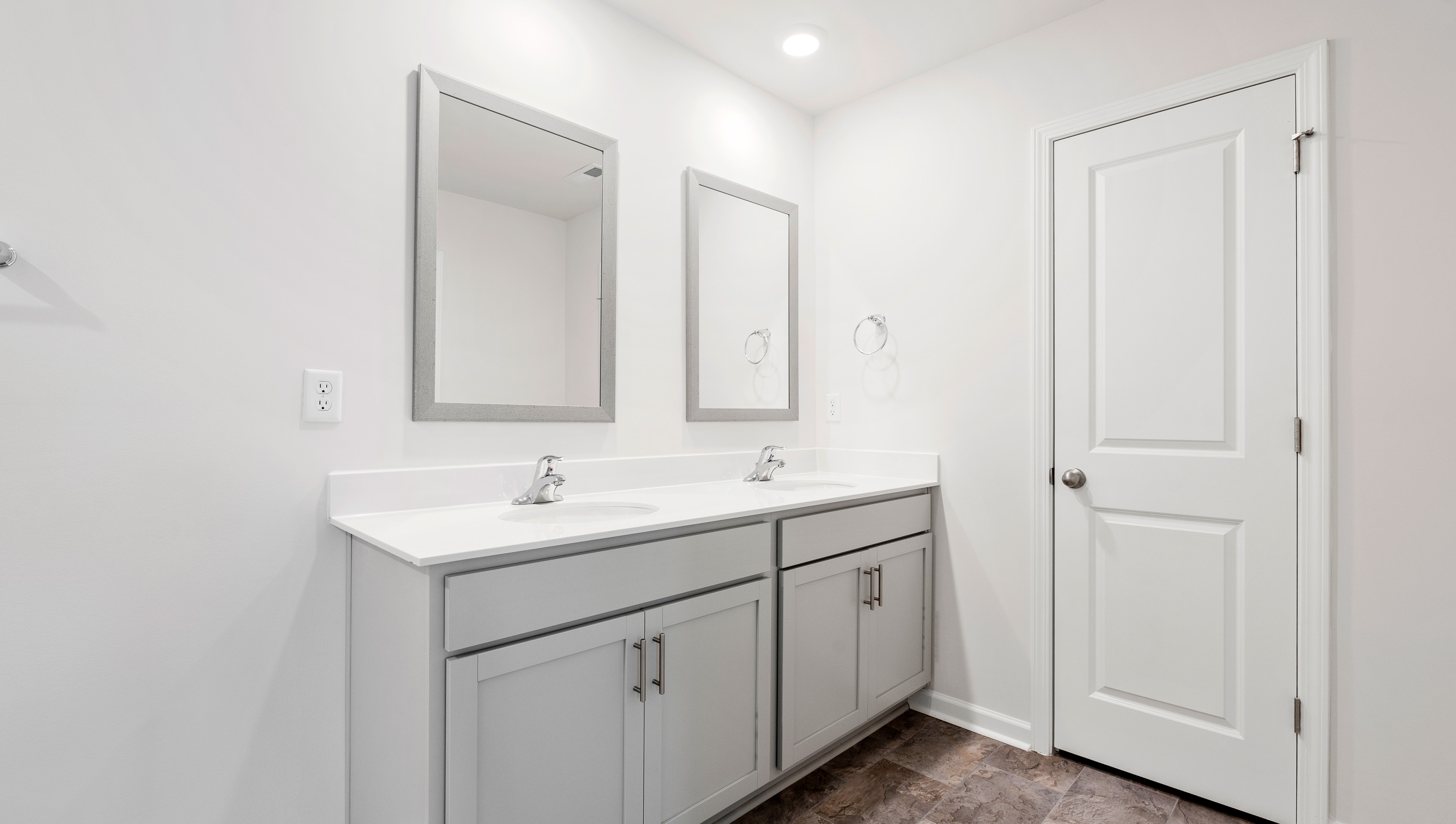 Bathroom with vanity and mirrors.