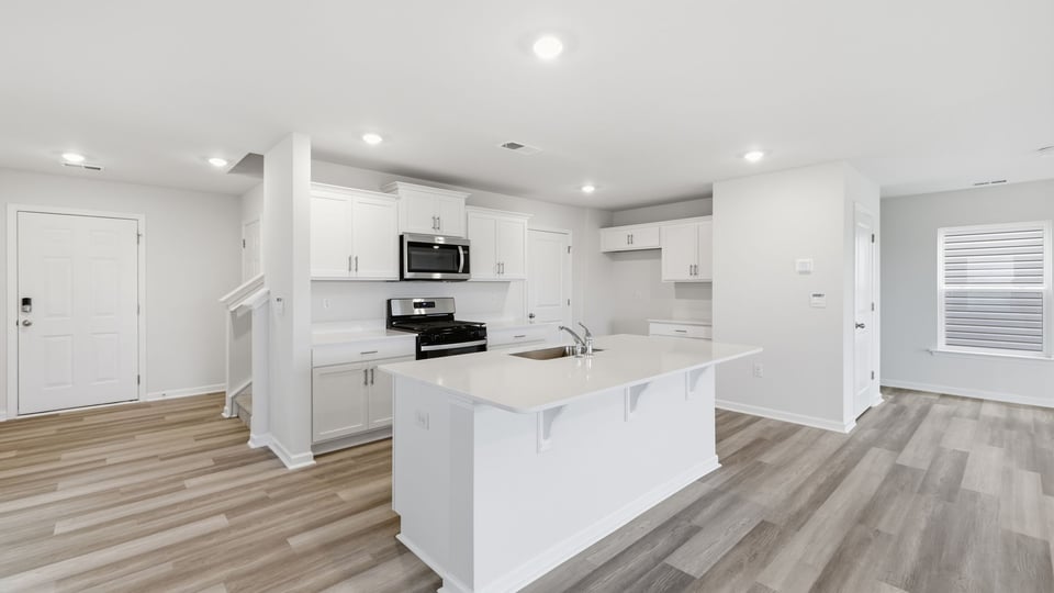 Kitchen and island with stainless steel appliances.
