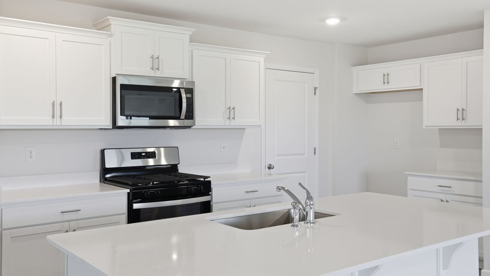 Kitchen and island with stainless steel appliances.