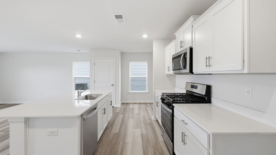 Kitchen and island with stainless steel appliances.