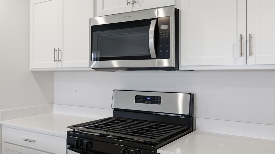 Kitchen and island with stainless steel appliances.