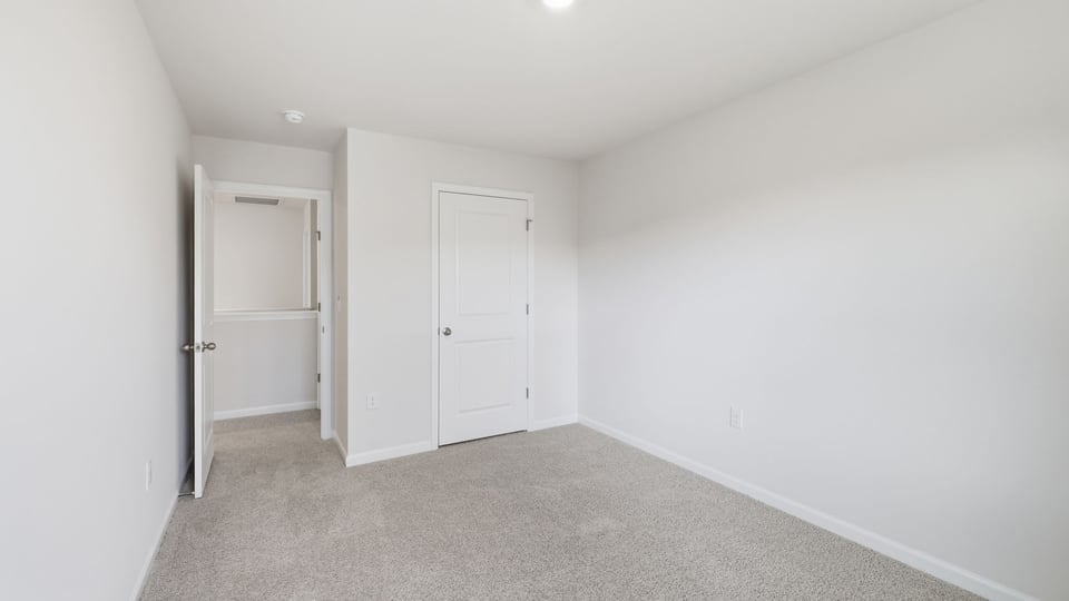 Bedroom with carpet and window.